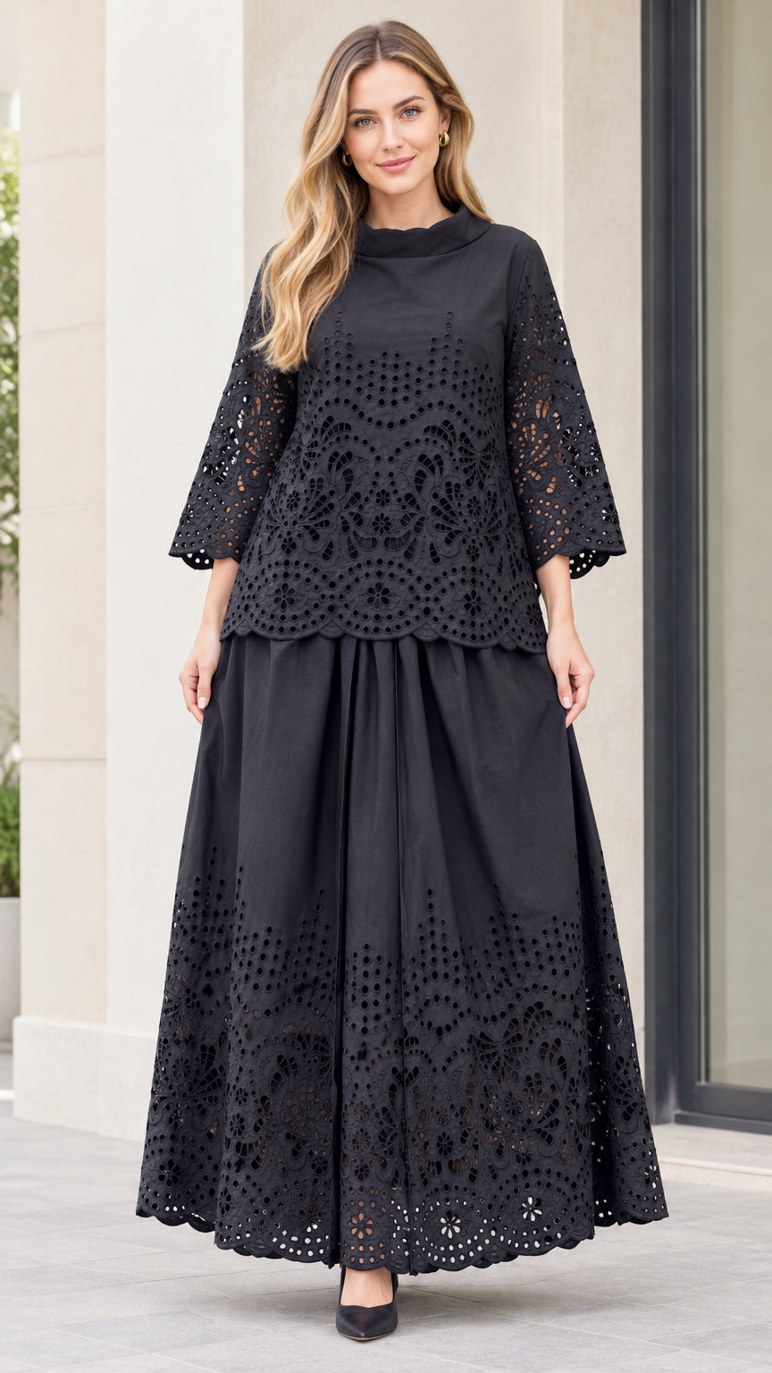 Front full-length view of woman wearing black eyelet embroidered mock neck top and maxi skirt set