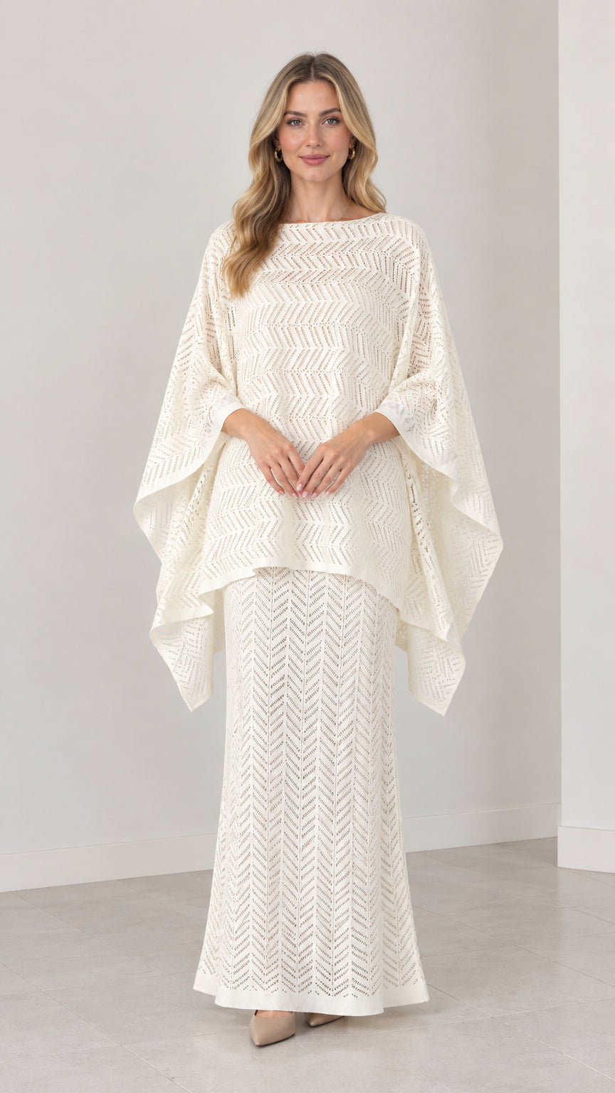 Front view of model wearing cream chevron pointelle knit cape top and maxi skirt set