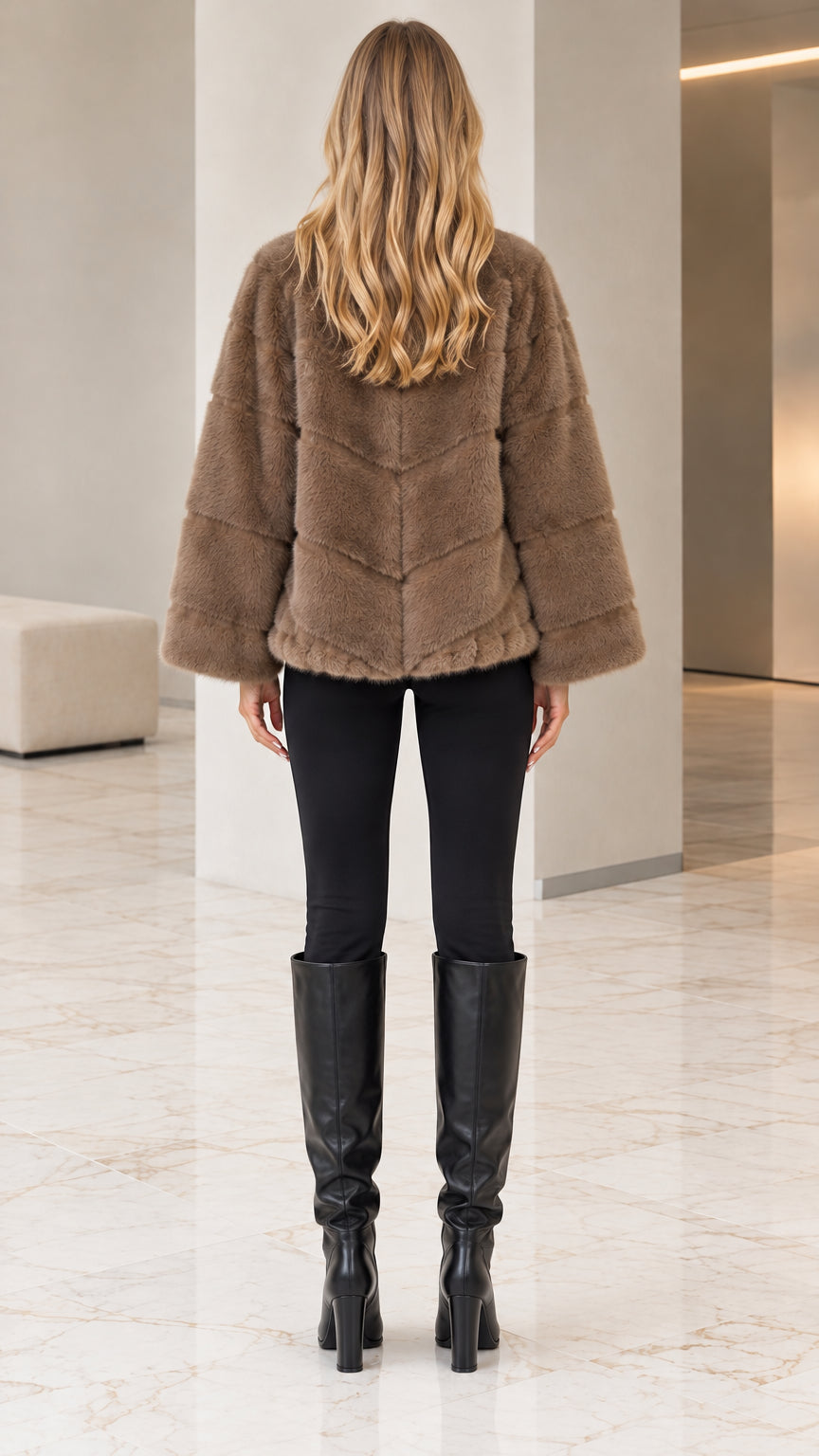 Rear view of woman showing chevron paneling on taupe faux fur coat