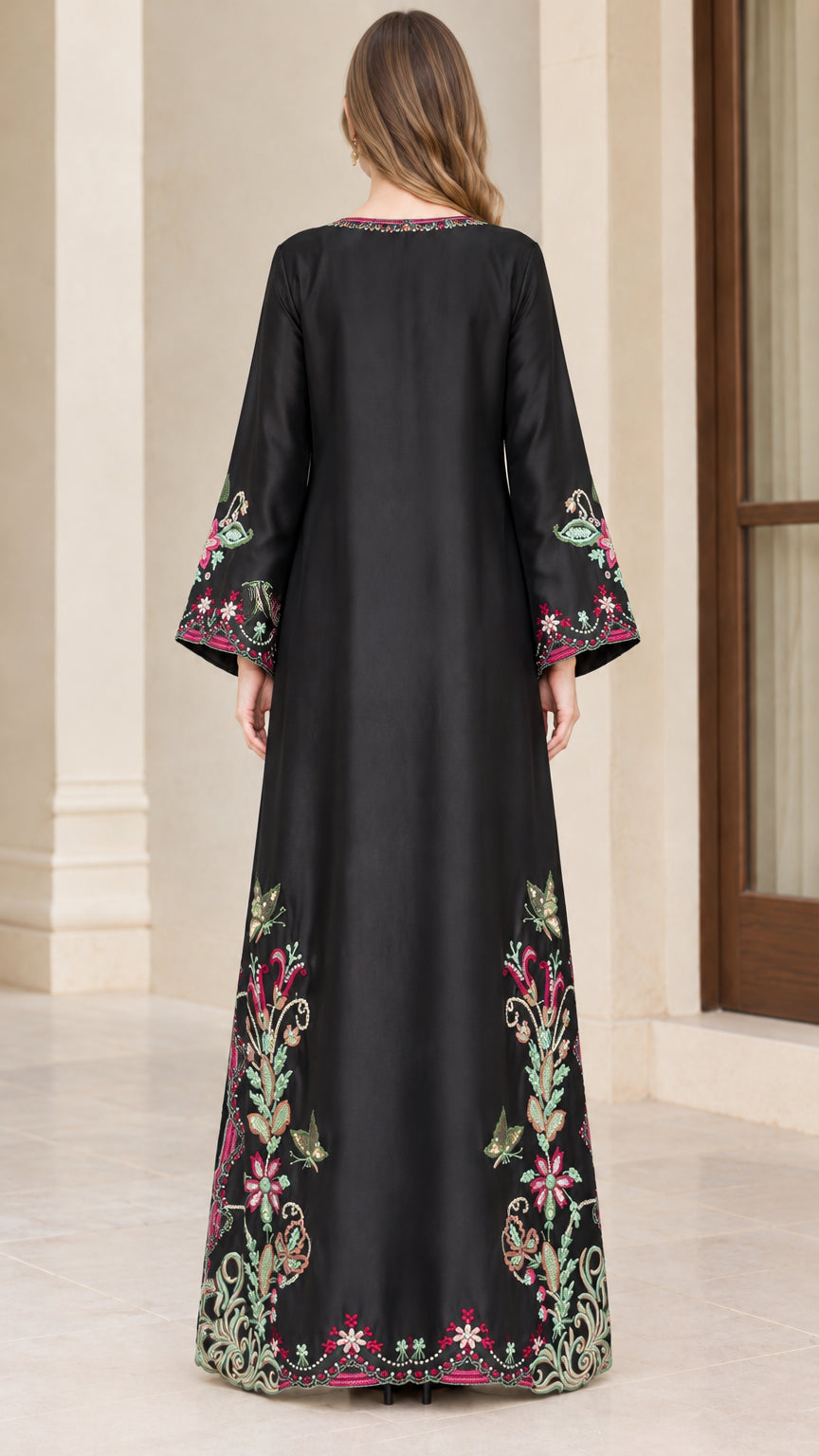 Back view of model showcasing black embroidered maxi dress silhouette