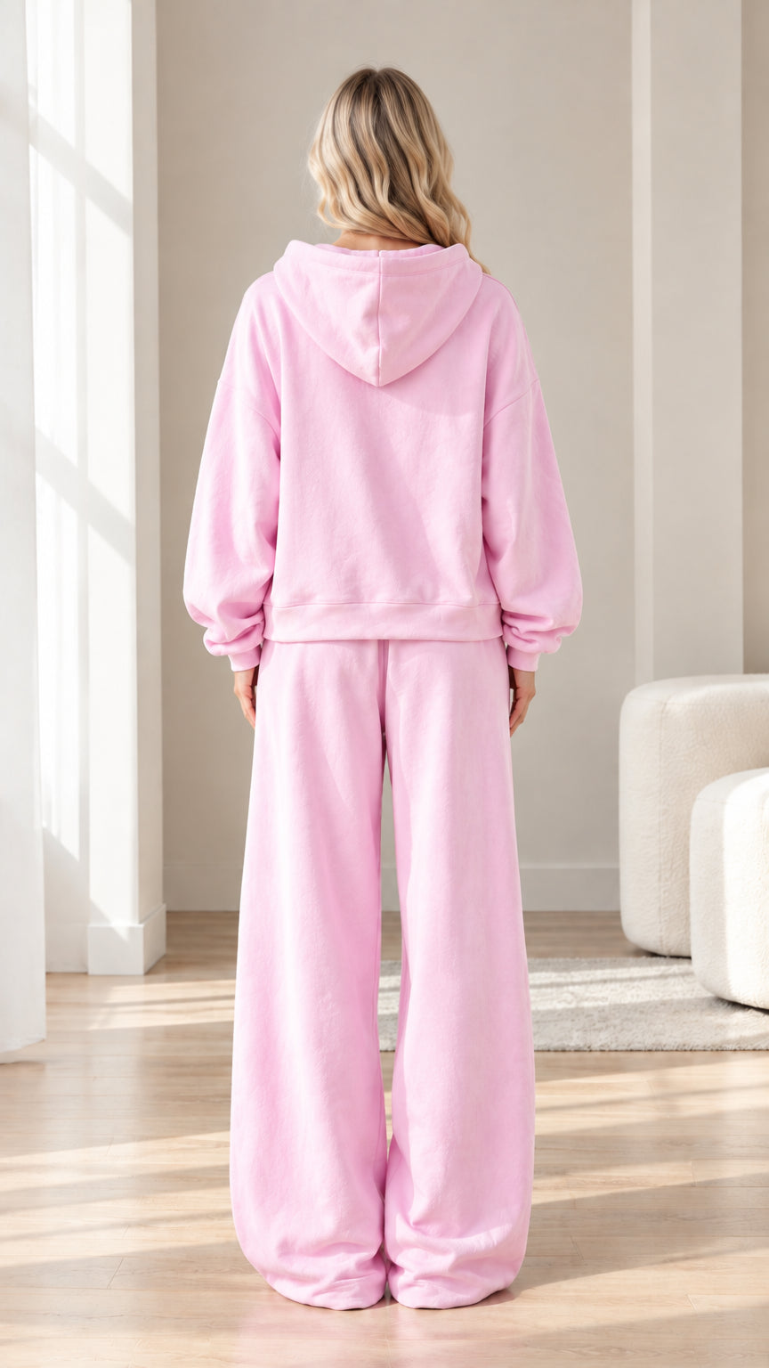 Back view of woman wearing pink hooded sweatshirt and relaxed sweatpants set