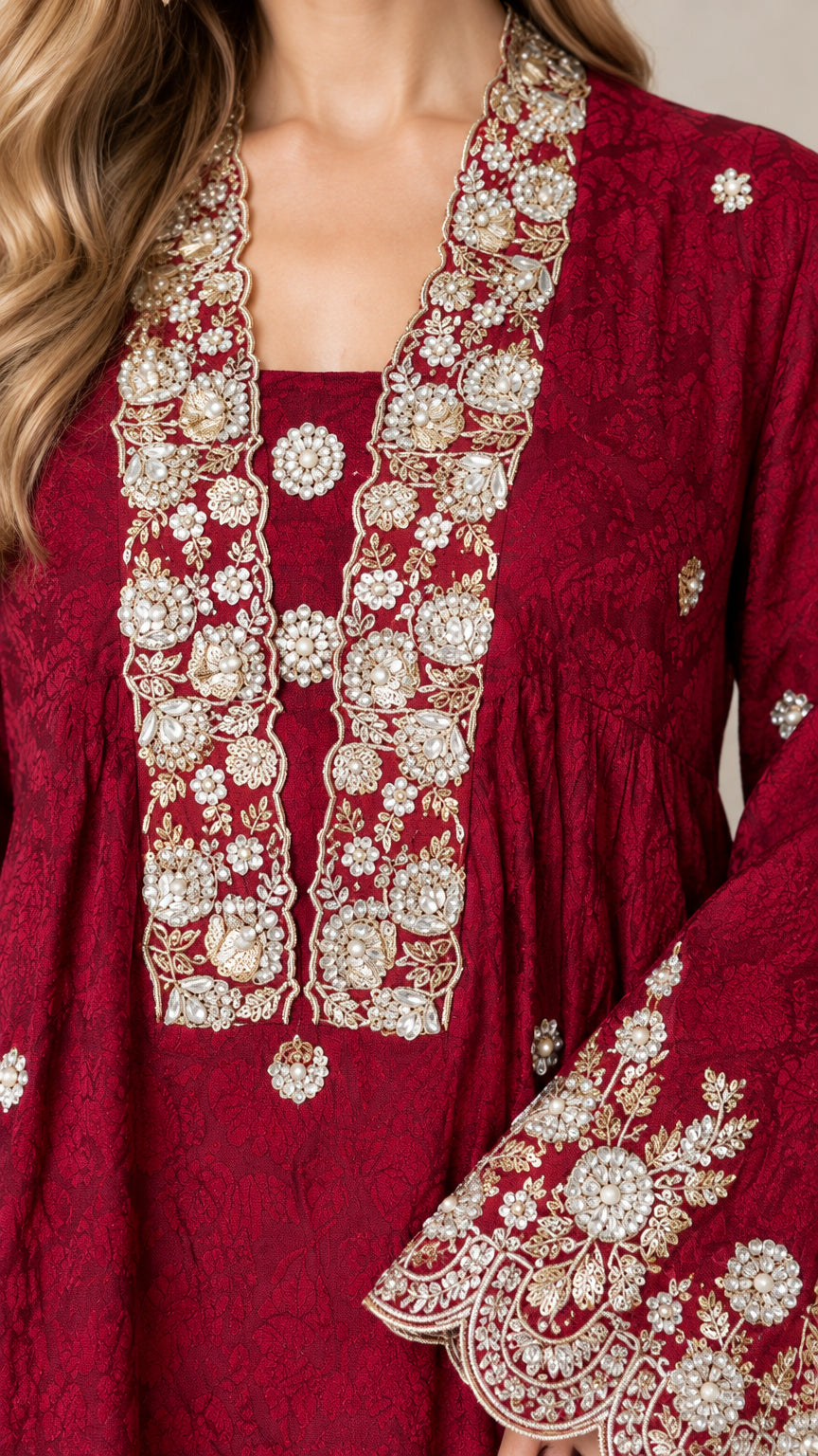 Close-up detail of neckline and cuff embroidery on burgundy tunic top