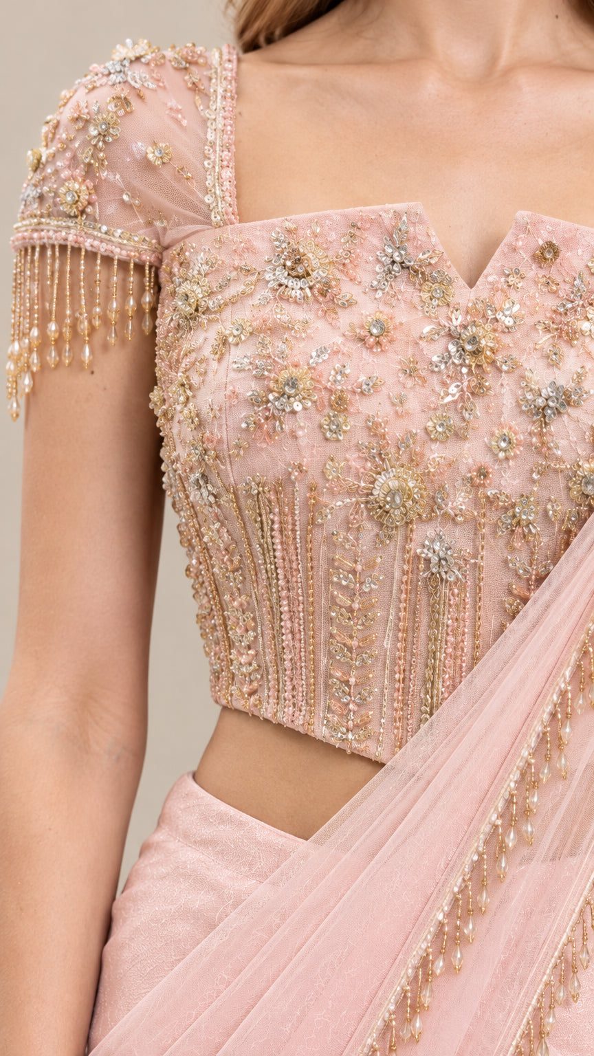 Close-up of beaded and sequined blush pink corset top with tassel sleeves