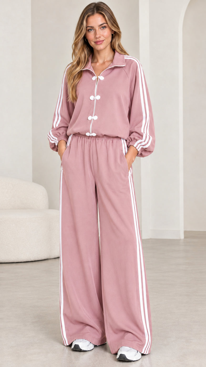 Model wearing dusty pink frog button two-piece tracksuit with side stripes