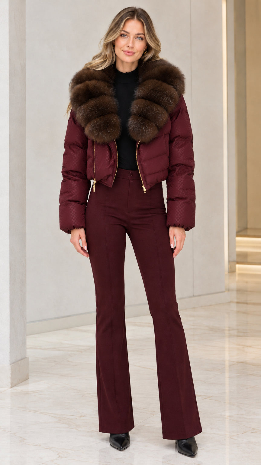 Model wearing burgundy red cropped puffer jacket with brown faux fur collar and wine red flare trousers