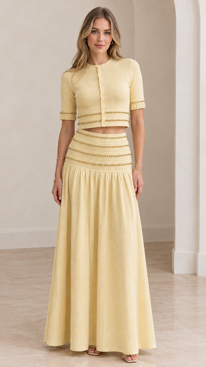 Model wearing butter yellow beaded crop top and pleated maxi skirt set front view