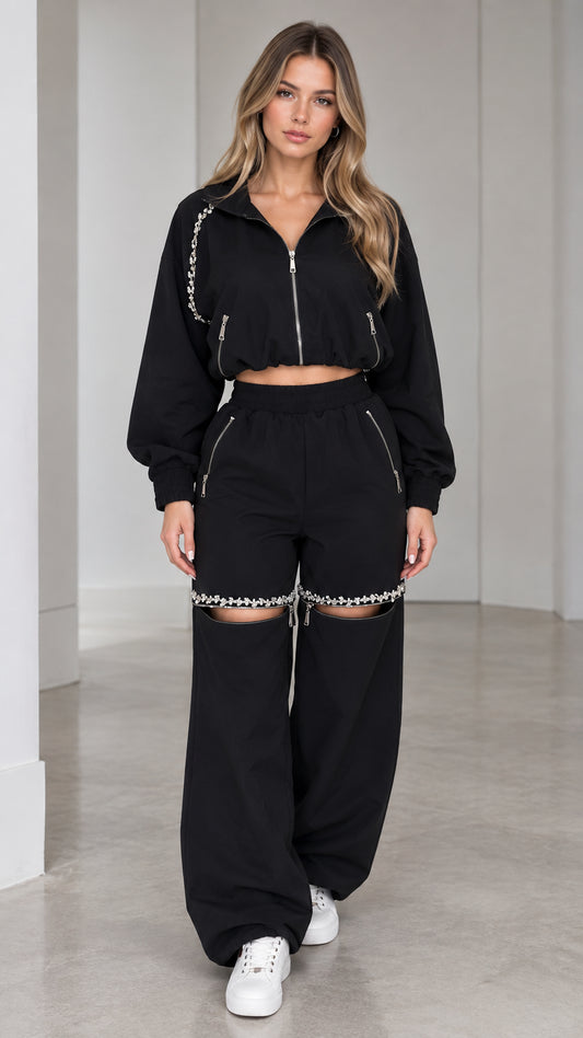 Front view of model wearing black rhinestone embellished cropped jacket and cut-out wide leg pants set