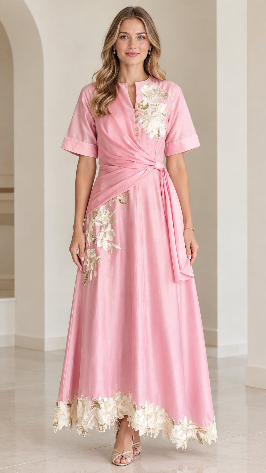 Front view of woman wearing pink floral embroidered twist-waist maxi dress