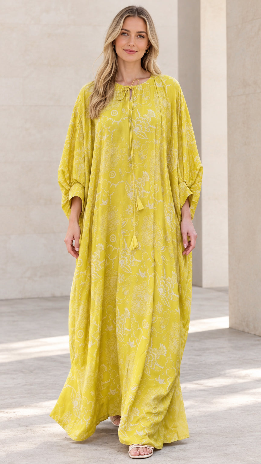 Front full-length view of woman wearing yellow floral print caftan maxi dress