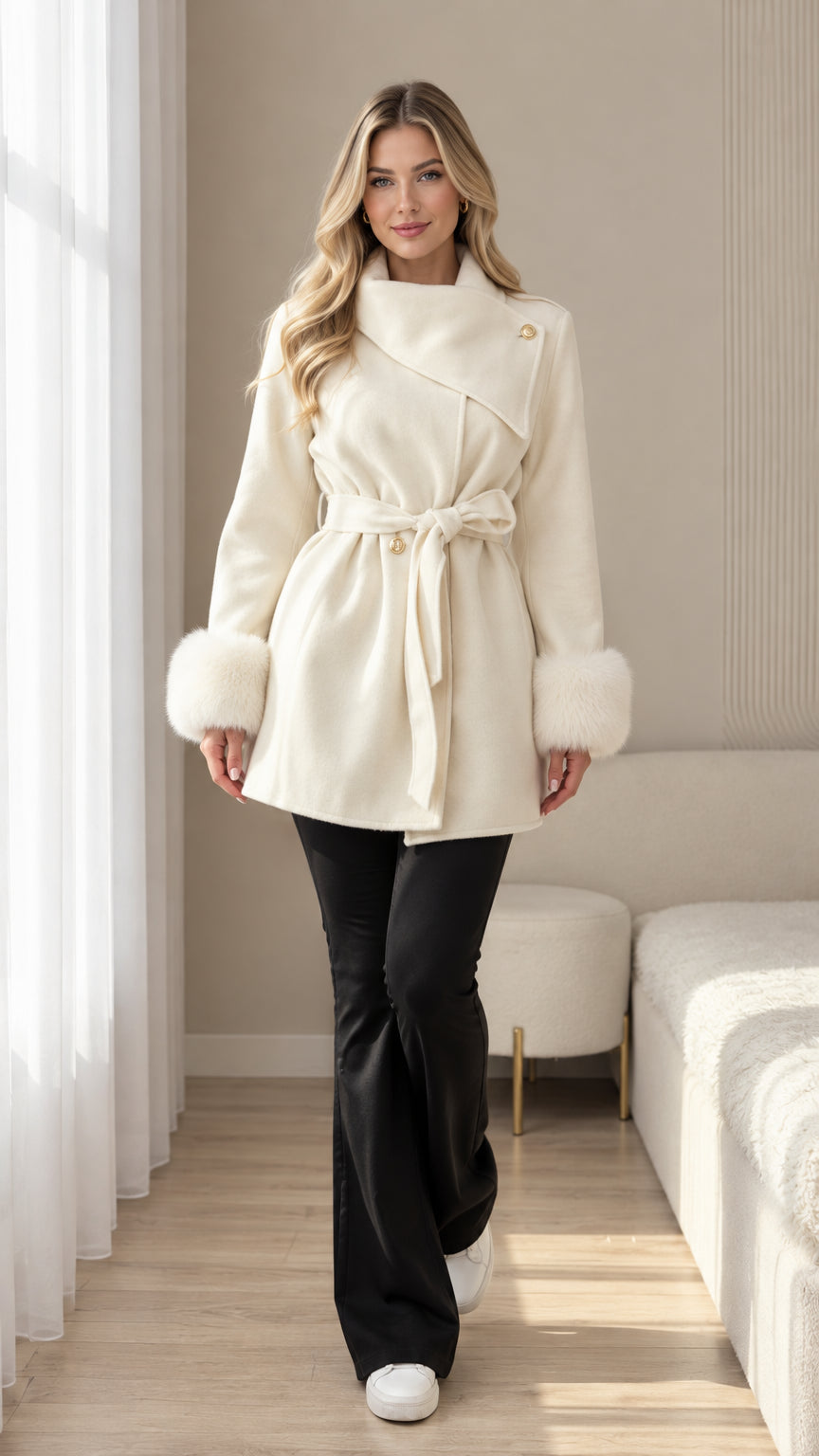 Front view of cream belted coat with faux fur cuffs and asymmetrical collar