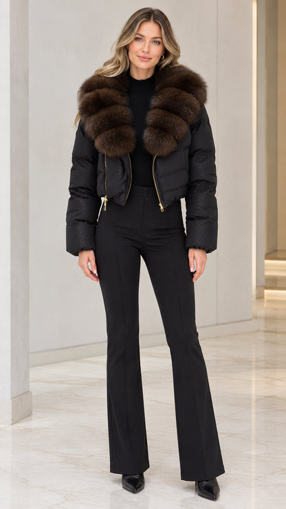 Front view of model wearing black cropped puffer jacket with brown faux fur collar and black flare pants