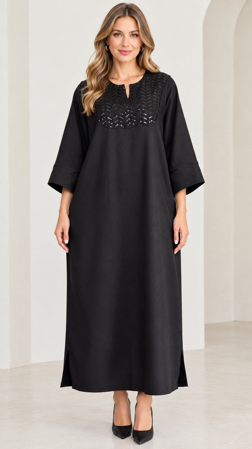 Front full-length view of woman wearing black sequin yoke kaftan maxi dress