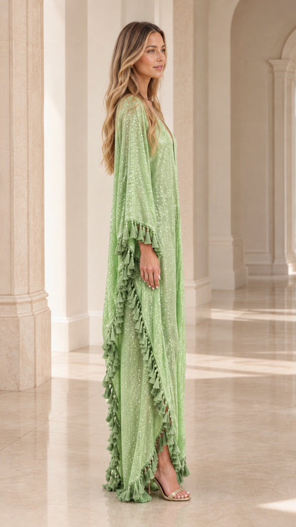 Side profile of woman in mint green sequin maxi kimono with tassel fringe trim