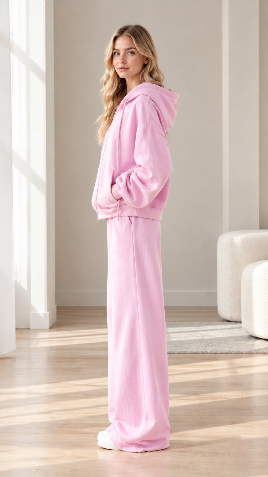 Side profile view of woman wearing pink fleece hoodie and matching wide-leg pants