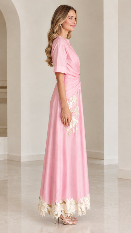 Side profile of woman in pink short-sleeve floral embroidered maxi dress