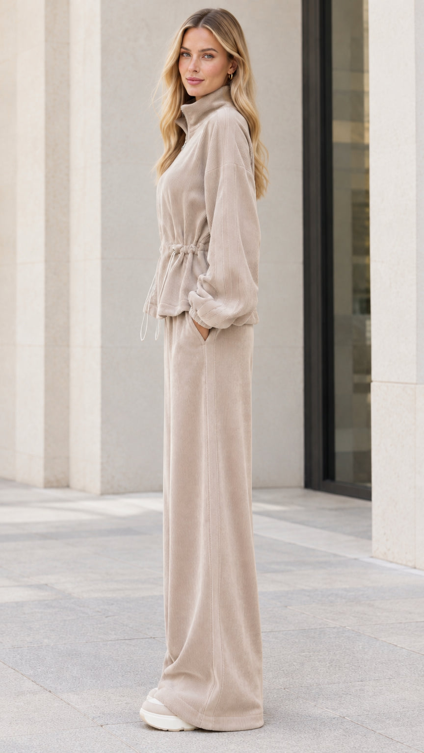 Side profile view of model wearing beige ribbed two piece tracksuit set
