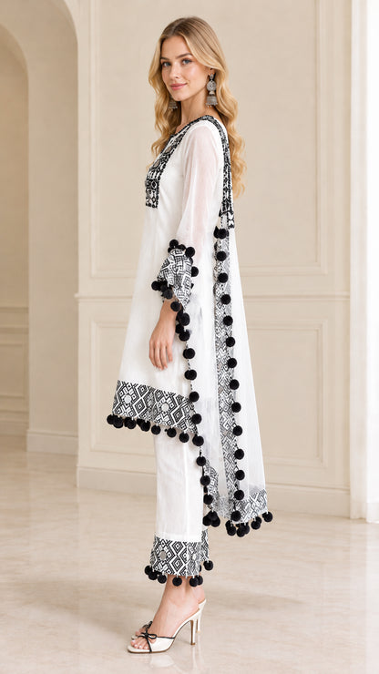 Side angle view of women's white tunic outfit showing flared hem and pom-pom trim