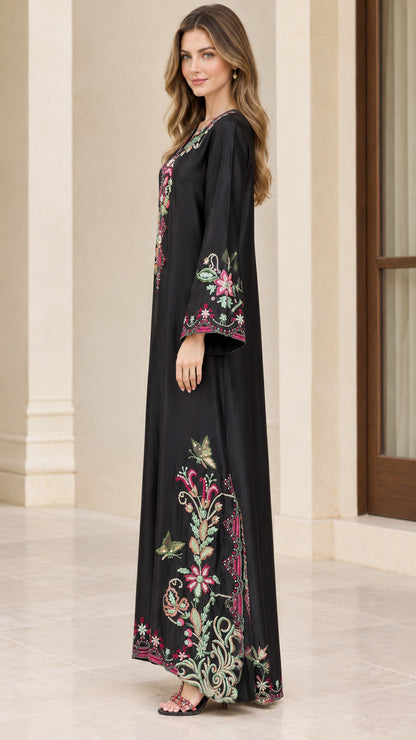 Side full-length view of model in black floral embroidered floor-length kaftan dress