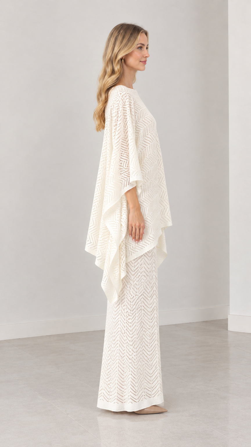 Side profile of cream pointelle knit poncho top and coordinating maxi skirt