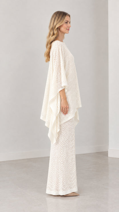 Side profile of cream pointelle knit poncho top and coordinating maxi skirt