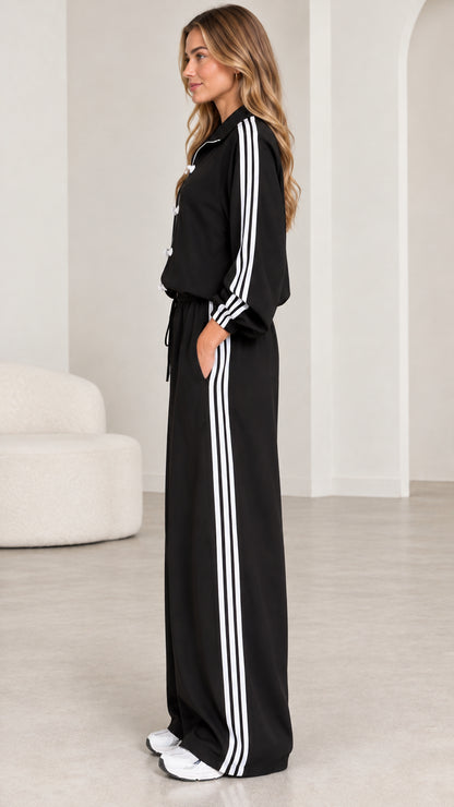 Side angle view of model wearing black two-piece wide-leg tracksuit set