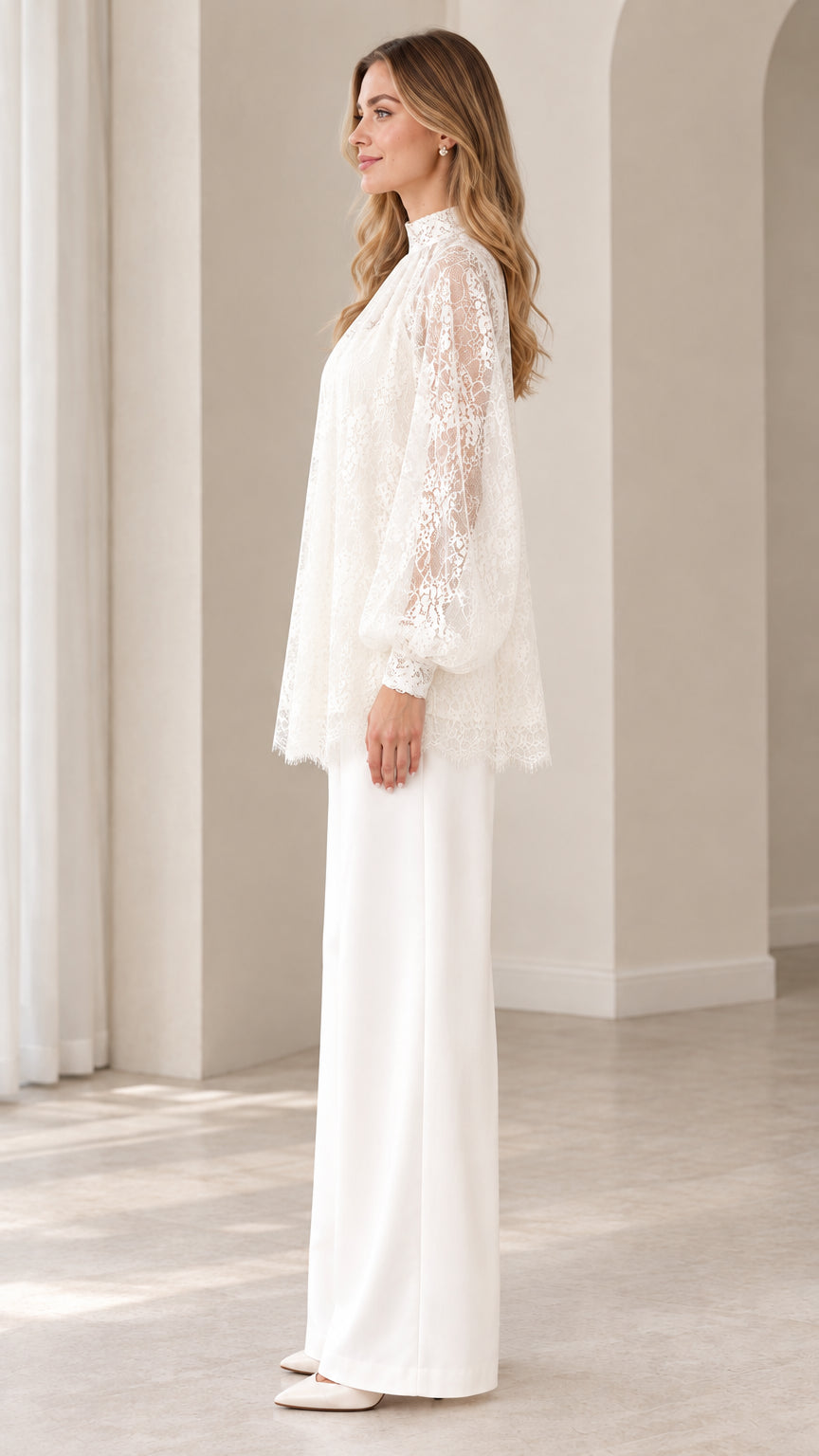 Side profile of woman in ivory white lace tunic top and tailored wide leg trousers