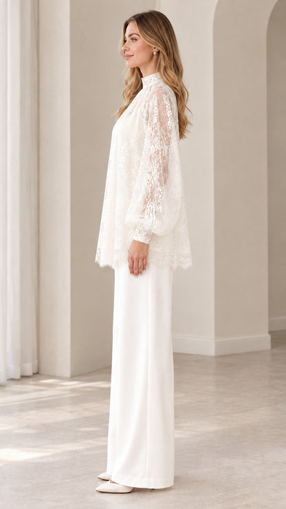 Side profile of woman in ivory white lace tunic top and tailored wide leg trousers