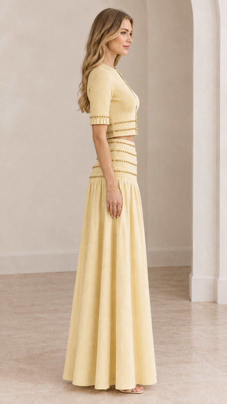Side profile of model wearing butter yellow two-piece crop top and maxi skirt set