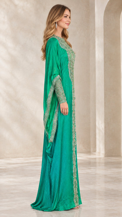 Side profile of emerald green flowing kaftan gown with draped cape sleeves