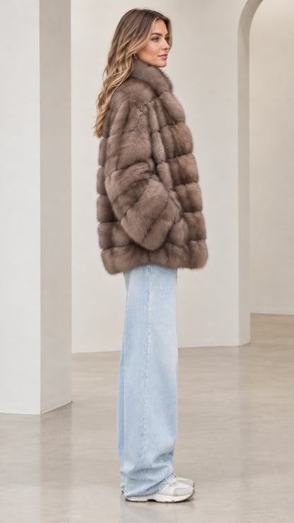 Side profile of model wearing the taupe paneled faux fur jacket