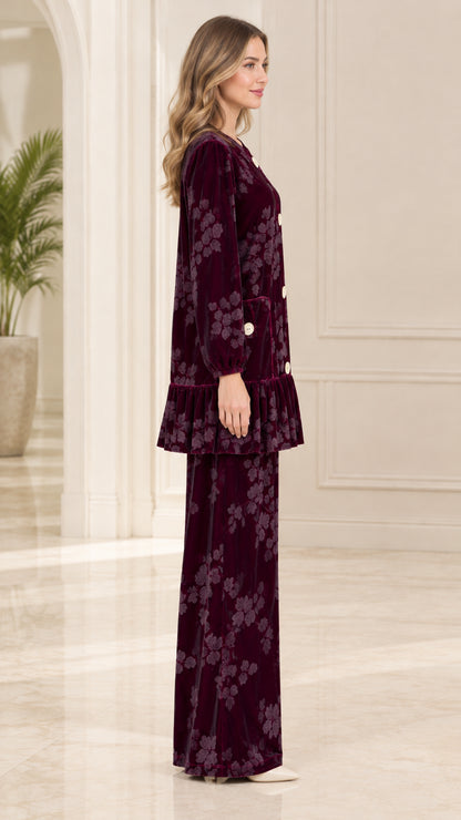 Side profile of model in burgundy velvet two-piece tunic and wide leg trousers set