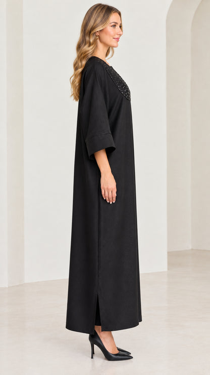 Side profile view of black relaxed kaftan maxi dress with side slit
