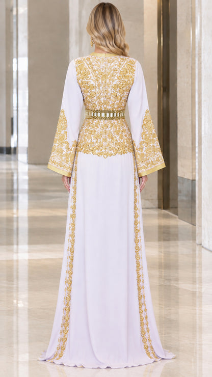 Back view of woman wearing floor-length white kaftan gown with gold embroidery
