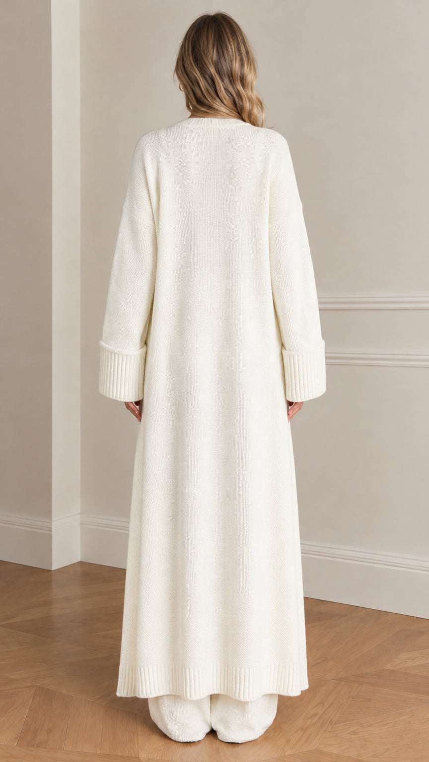 Back view of woman wearing cream floor-length duster cardigan and knit pants