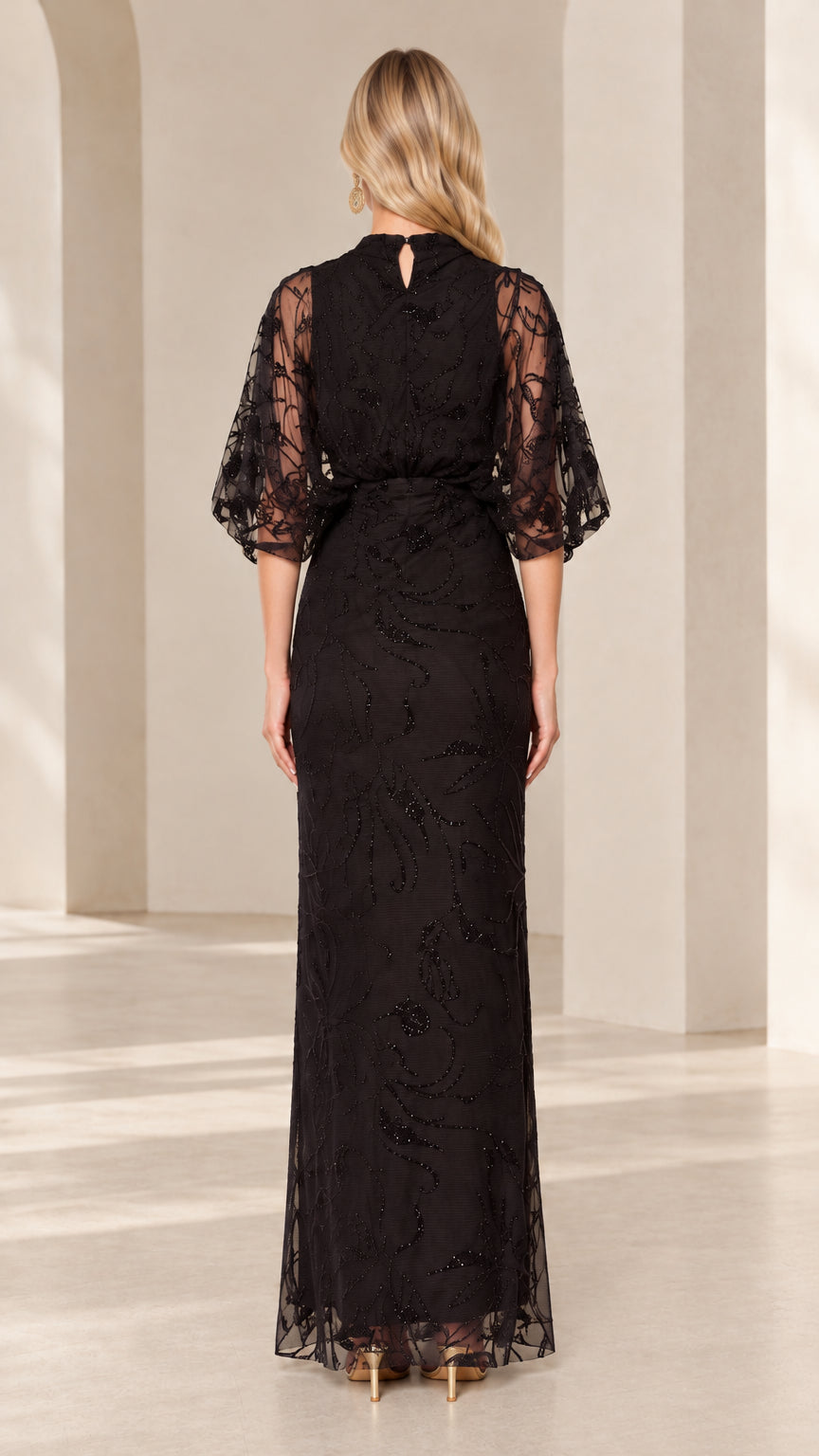 Back view of woman wearing black beaded high-neck evening gown featuring keyhole closure