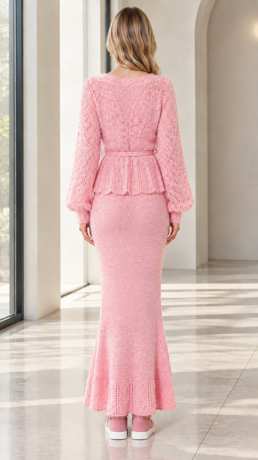 Back view of woman wearing pink long sleeve knit peplum set and maxi skirt