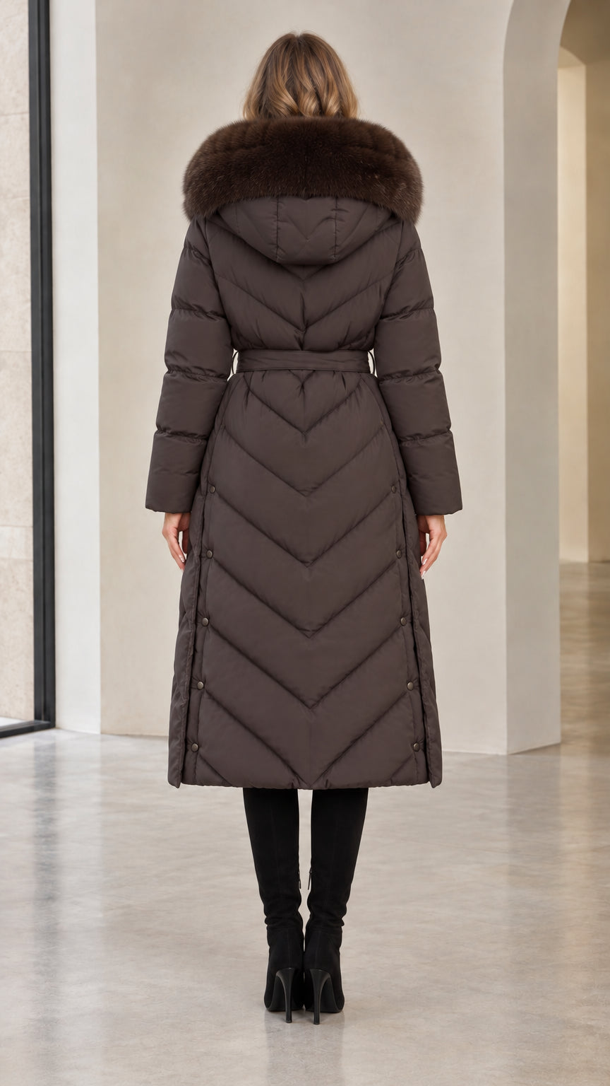 Back view of woman in dark brown chevron quilted long winter coat with hood