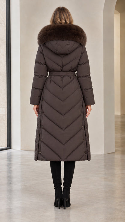 Back view of woman in dark brown chevron quilted long winter coat with hood