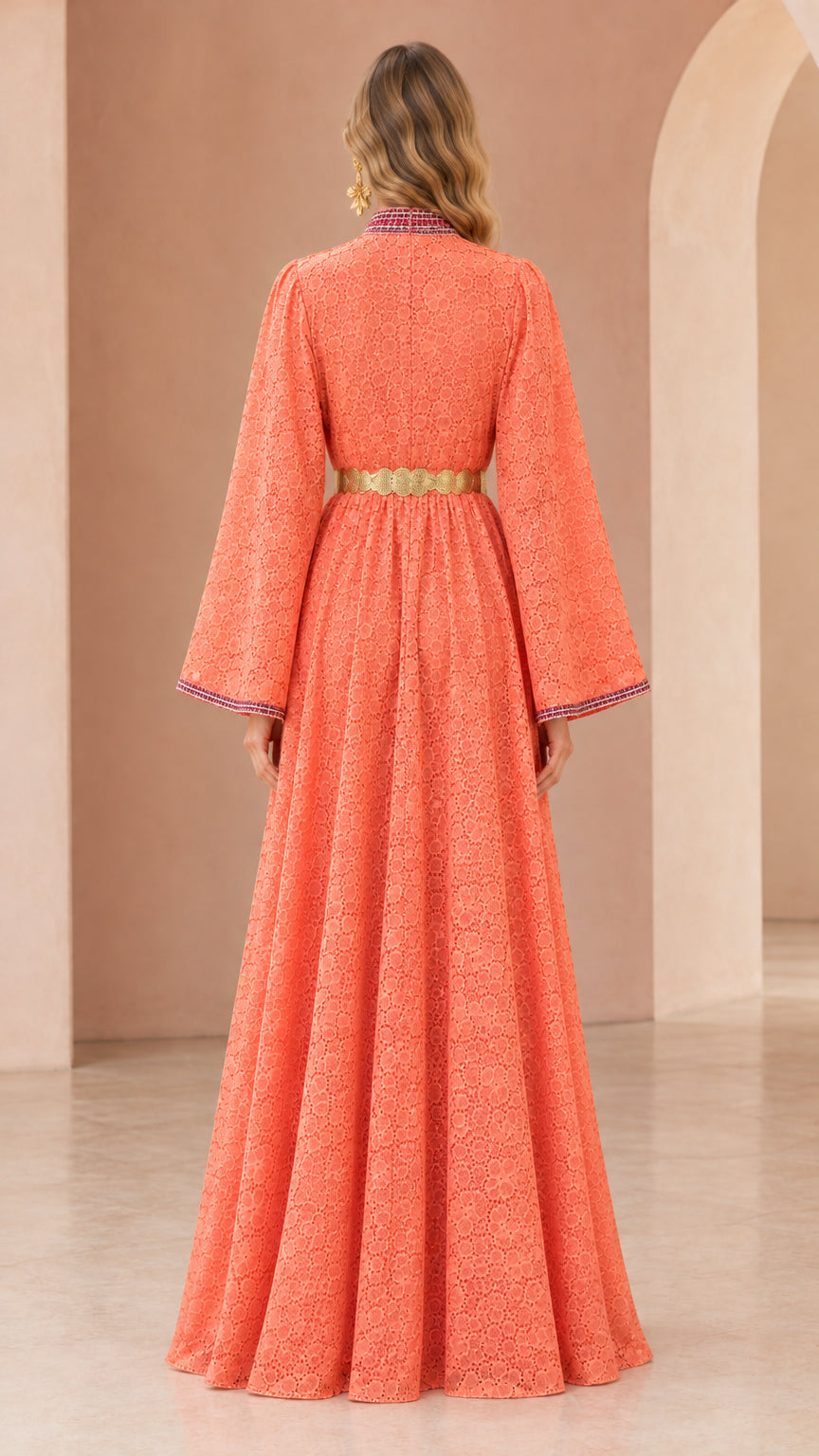 Back view of woman wearing floor-length coral lace kaftan dress with belt