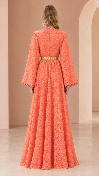 Back view of woman wearing floor-length coral lace kaftan dress with belt