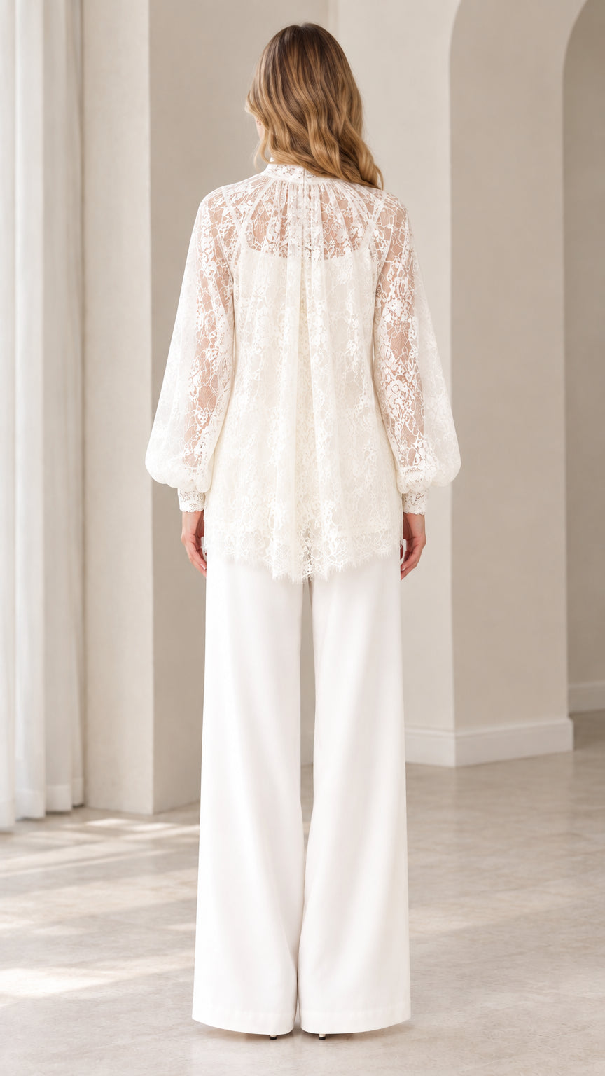Back view of woman wearing elegant ivory white lace blouse and wide leg trousers