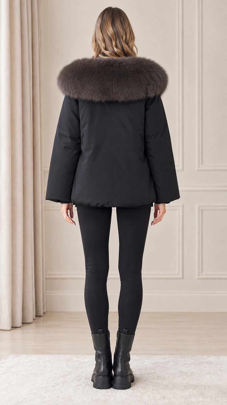 Back view of model wearing black winter parka with voluminous plush trimmed hood