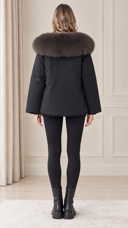 Back view of model wearing black winter parka with voluminous plush trimmed hood