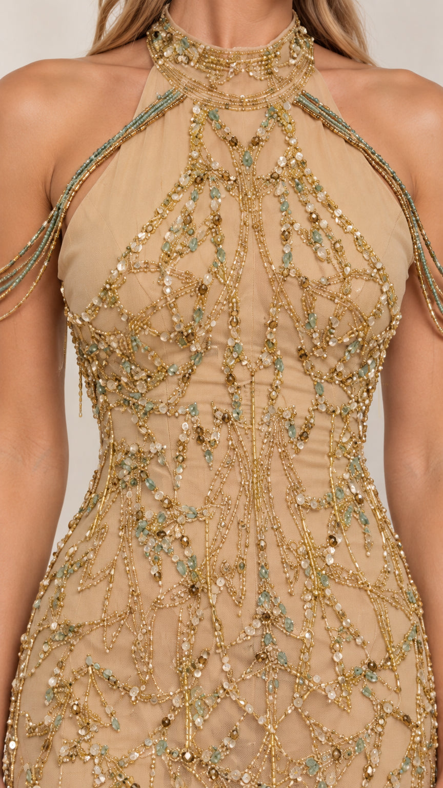 Close-up of intricate gold beading and draped shoulder detail on halter neckline