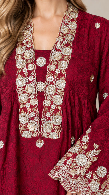Close-up detail of neckline and cuff embroidery on burgundy tunic top