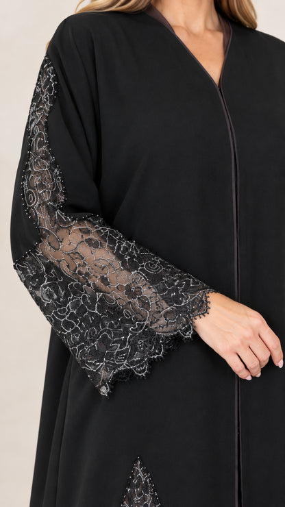 Close-up detail of sheer lace cuff and sleeve on black abaya