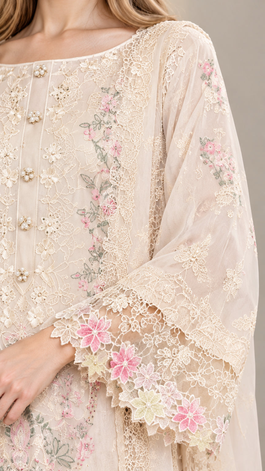 Close-up detail of delicate floral embroidery and scalloped lace cuffs on tunic