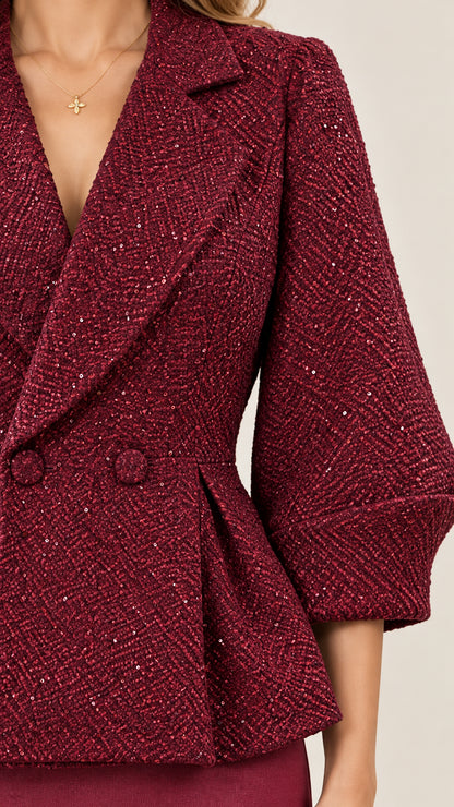 Close-up of burgundy shimmering tweed texture and tailored jacket lapel