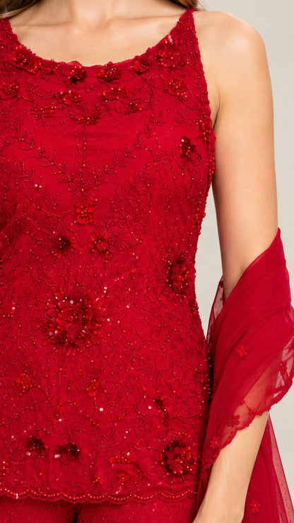 Close-up detail of red tunic top showing intricate beading and 3D floral embellishments