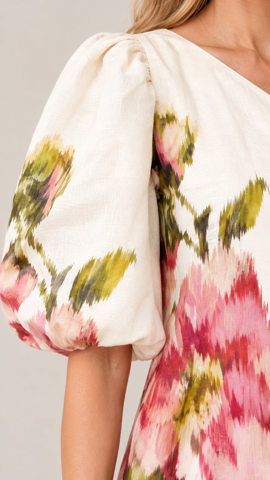 Close-up detail of textured woven fabric and dramatic puff sleeve